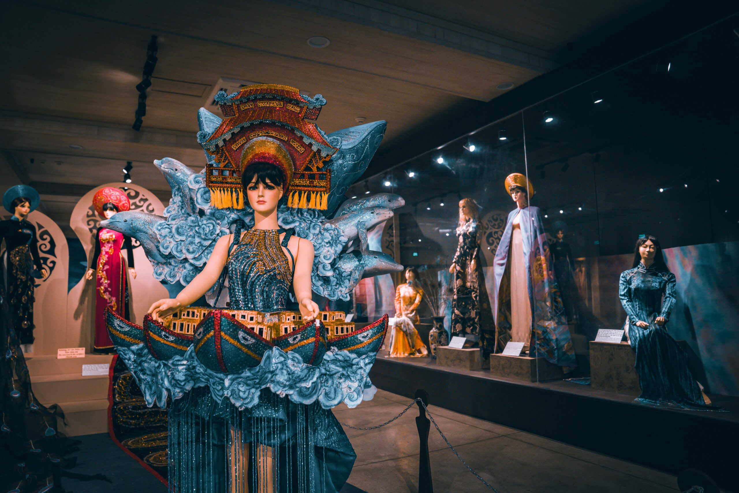 Dazzling fashion exhibition featuring elaborately dressed mannequins in ornate gowns.
